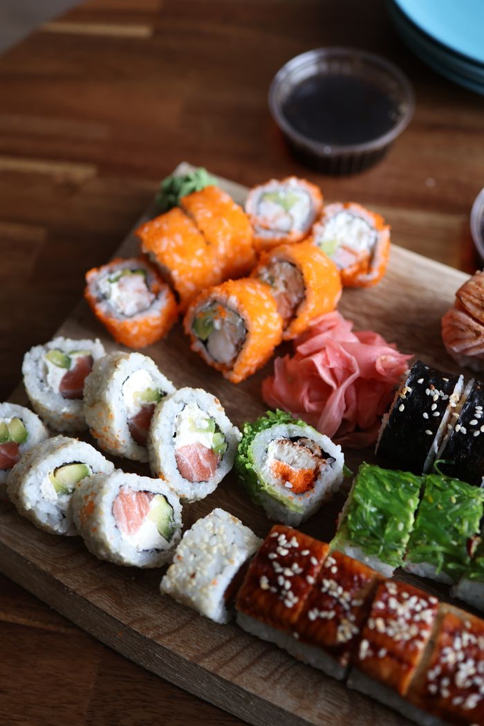 Home Delicious sushi assortment with salmon, avocado, and more on a wooden board.