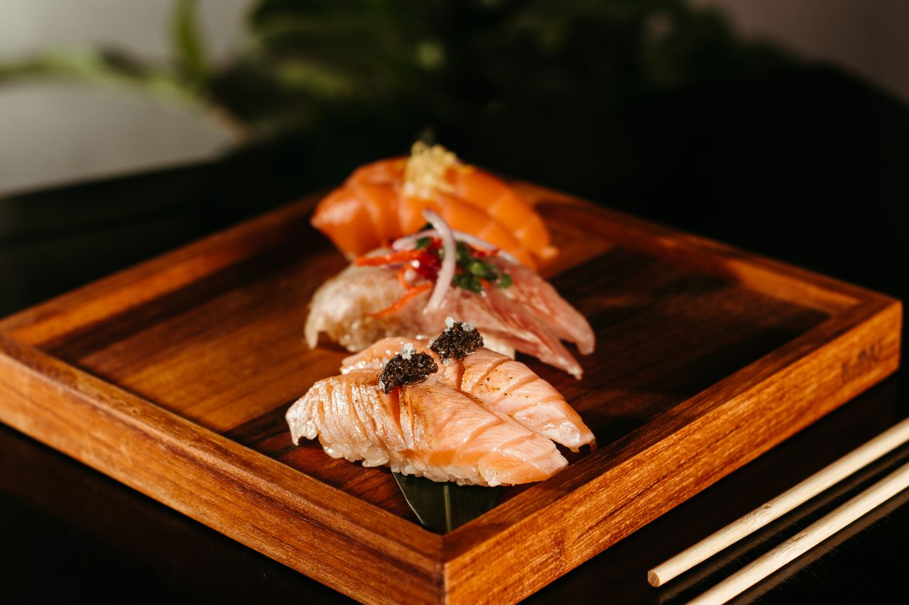 Home Close-up of assorted sushi on a wooden tray, featuring fresh salmon and caviar.