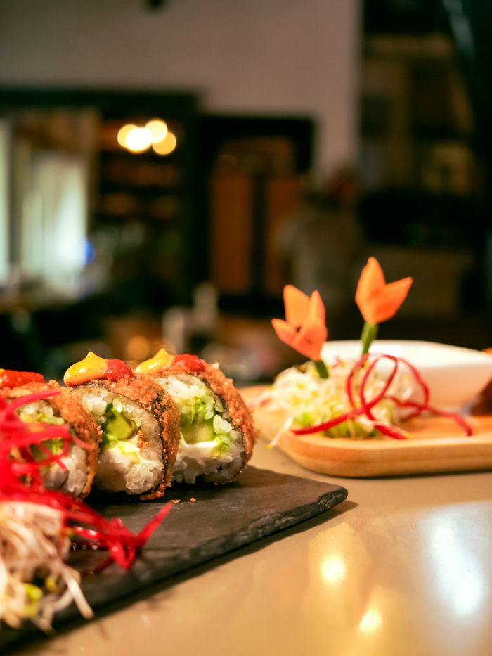 Home Close-up of gourmet sushi rolls with elaborate garnish, perfect for culinary themes.