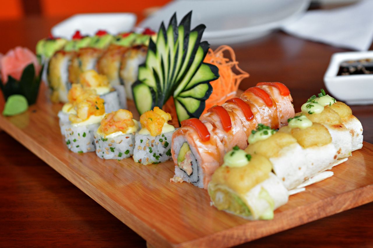 Home Colorful sushi platter featuring various rolls with decorative garnishes, showcasing culinary art.